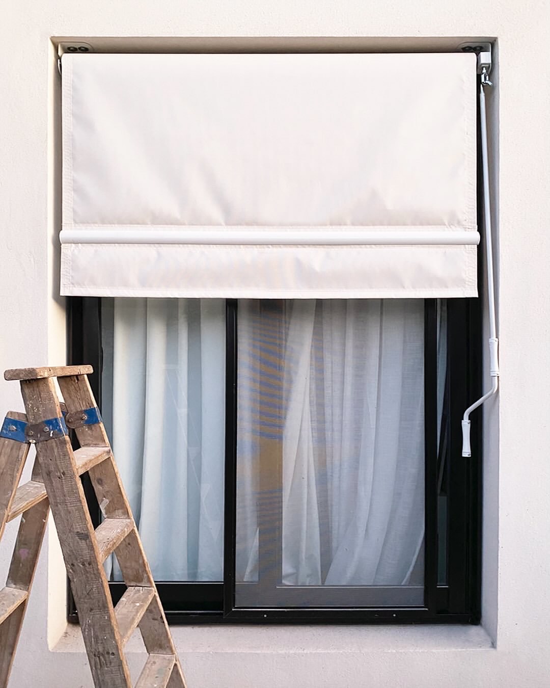 Toldo vertical de tela screen en una ventana